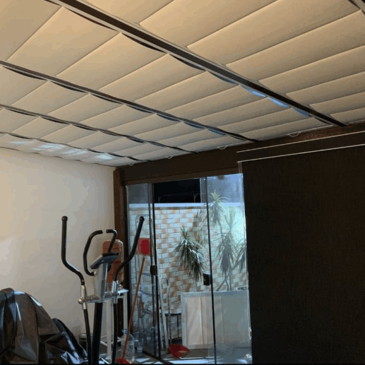 Cortinas claras distribuídas em módulos no teto.